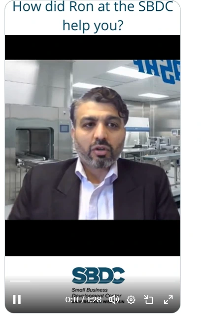 The founder of Advasaf LLC, a Brookfield, Wisconsin-based medical device contract services company, speaks on camera inside a clean, professional medical manufacturing facility. The video thumbnail features the question "How did Ron at the SBDC help you?" overlaid on the image, along with the Wisconsin SBDC (Small Business Development Center) logo. This short-form video highlights the real-world impact of SBDC advisory services on a minority-owned, FDA-regulated small business in Wisconsin.